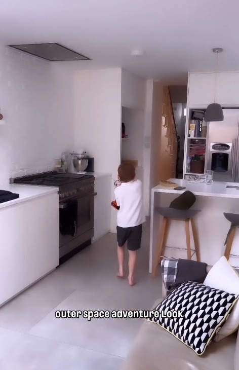 Danny Jones' son holding Lego walks through open-plan kitchen and dining area
