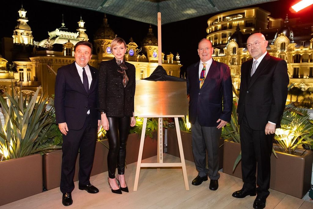 charlene with plaque beside four men in all black