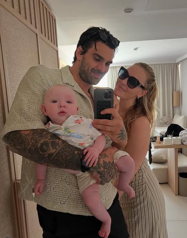 Adam Collard and Laura Woods taking a selfie with a baby