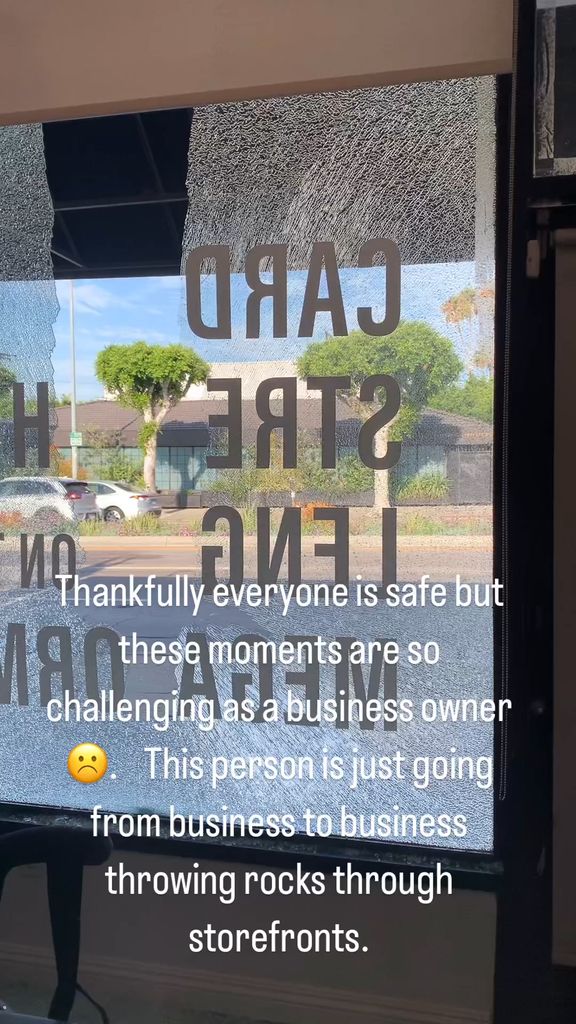 Photo of a storefront smashed through by a brick