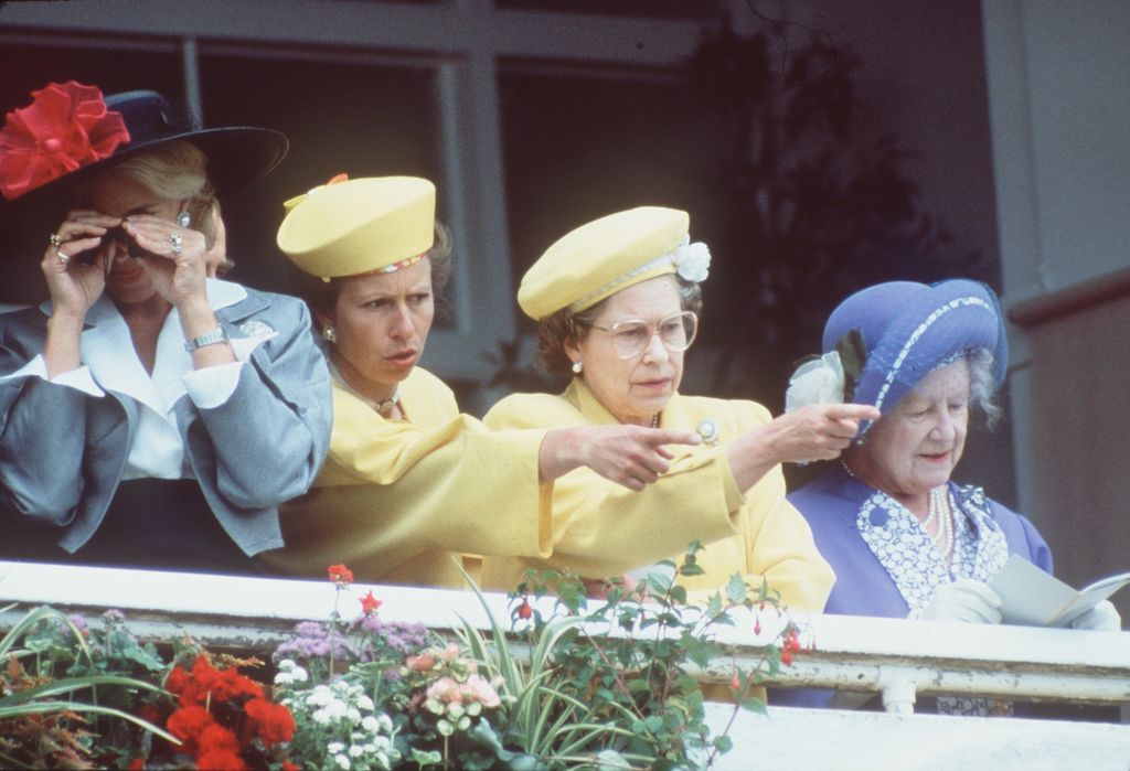 Princesa Anne e Rainha Elizabeth II em amarelo apontando 