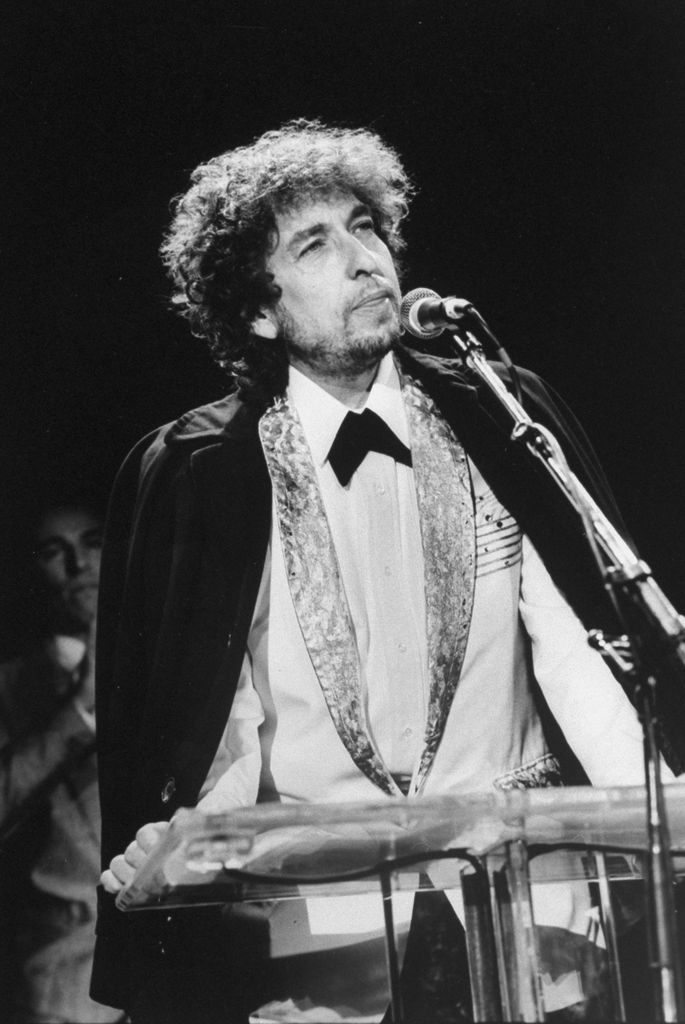 Black-and-white photo of Bob Dylan in front of a microphone