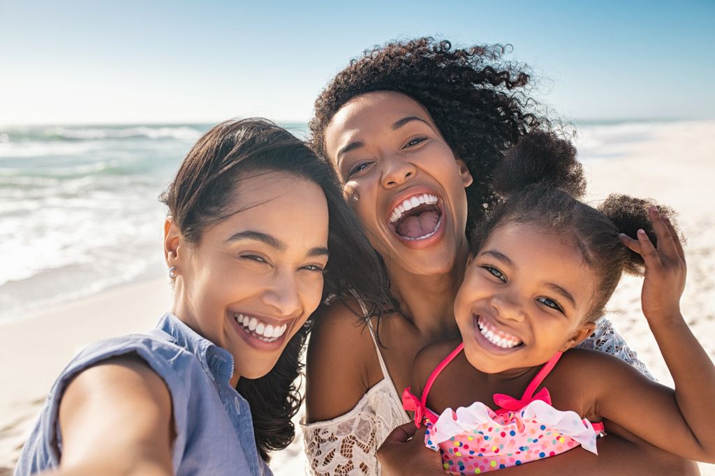 Portrait Of Smiling young African American Woman With Child Taking Selfie