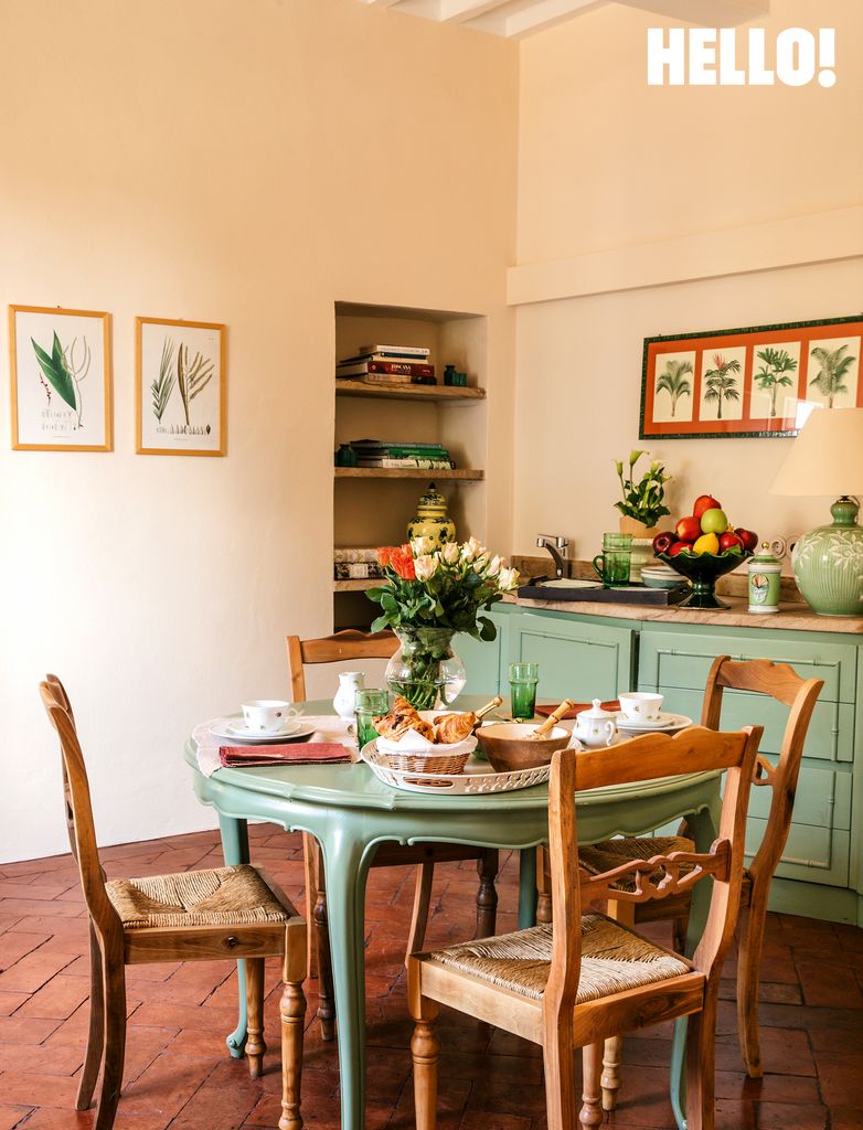 A green vintage table with a French porcelain coffee set is surrounded by natural rush chairs in Villa Talamo