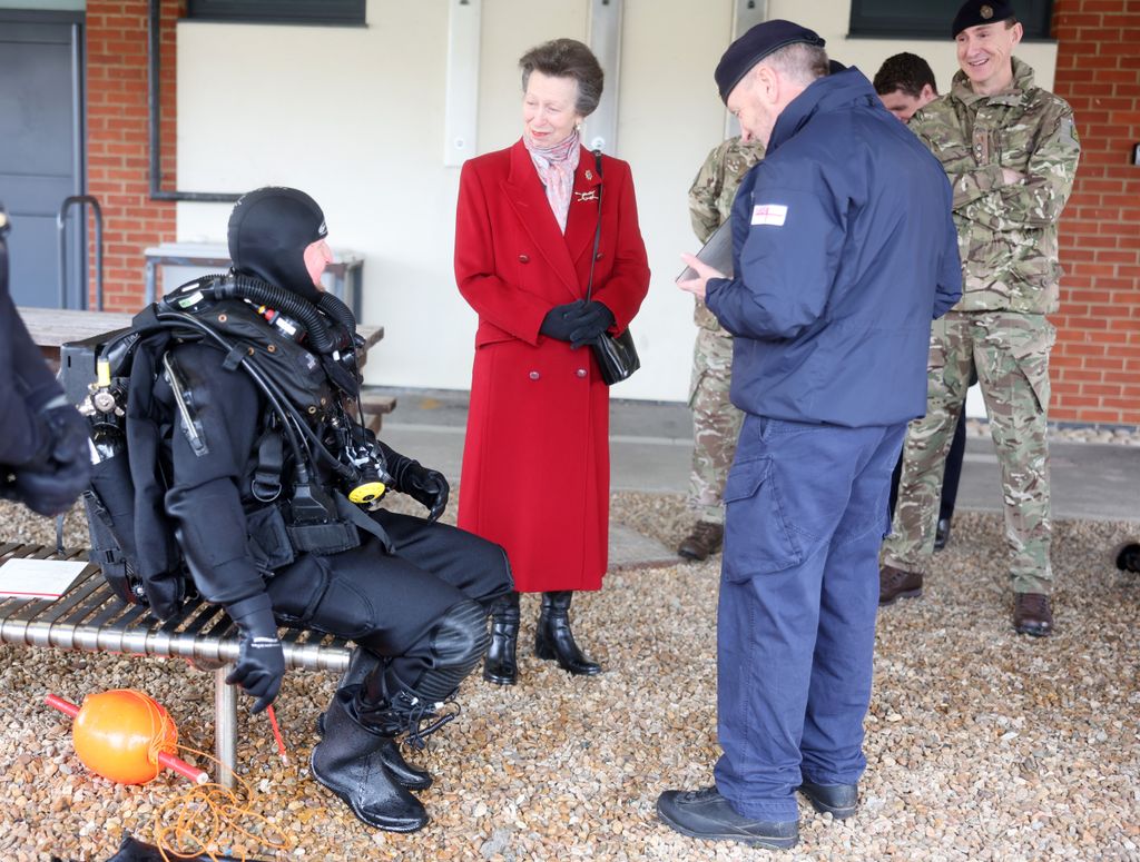 Princesa Anne falando com um operador de descarte de explosivos subaquáticos em traje de mergulho