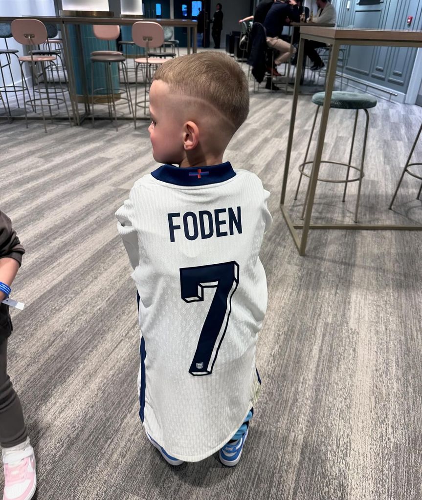The mini football star loves wearing his dad's kit
