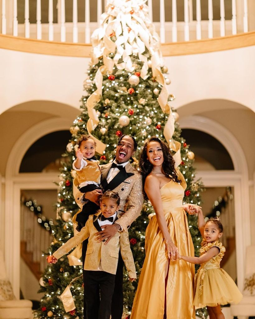 Nick Cannon and Brittany Bell with their three children in front of the Christmas tree
