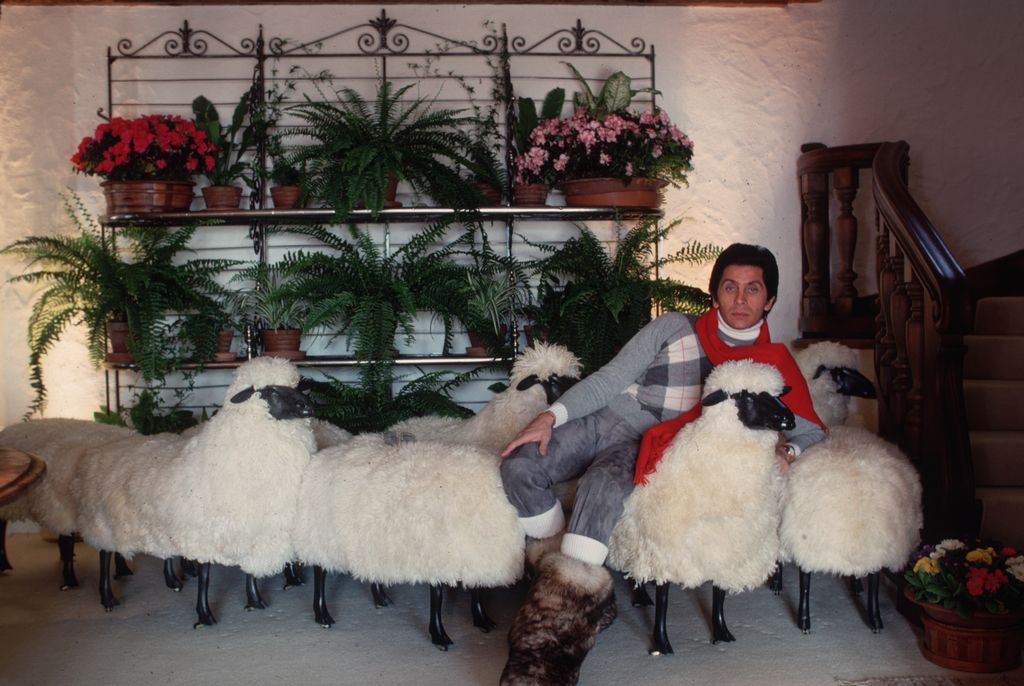 February 1977:  In a chalet in the ski resort of Gstaad, dress designer Valentino relaxes on a sofa made of sheep. He started in the trade working for Desses and then Laroche before opening his own couture house.  (Photo by Slim Aarons/Getty Images)