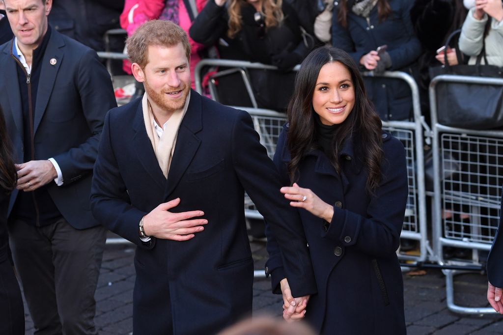 Harry and Meghan smiling in front of crowds in Nottingham