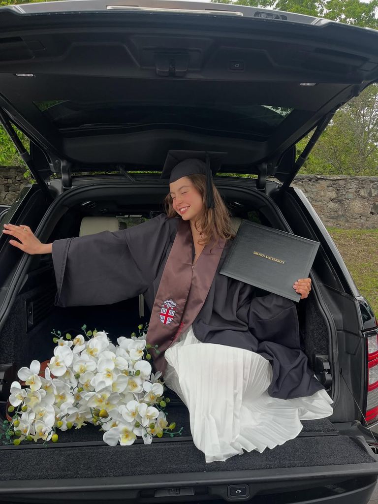 Carys Douglas poses for a photo inside a car at Brown University during her graduation, shared on Instagram