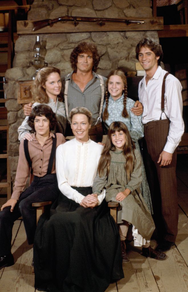 Pictured: (back row l-r) Melisssa Sue Anderson as Mary Ingalls Kendall, Michael Landon as Charles Philip Ingalls, Melissa Gilbert as Laura Elizabeth Ingalls Wilder, Linwood Boomer as Adam Kendall (front row l-r) Matthew Laborteaux as Albert Quinn Ingalls, Karen Grassle as Caroline Quiner Holbrook Ingalls, Lindsay or Sydney Greenbush as Carrie Ingalls
