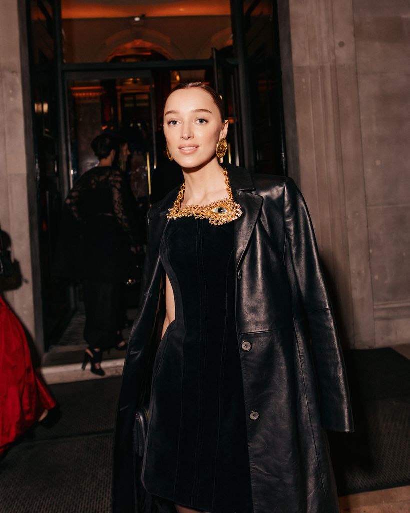 A closer look at Phoebe's black leather coat, black mini dress and gold jewellery