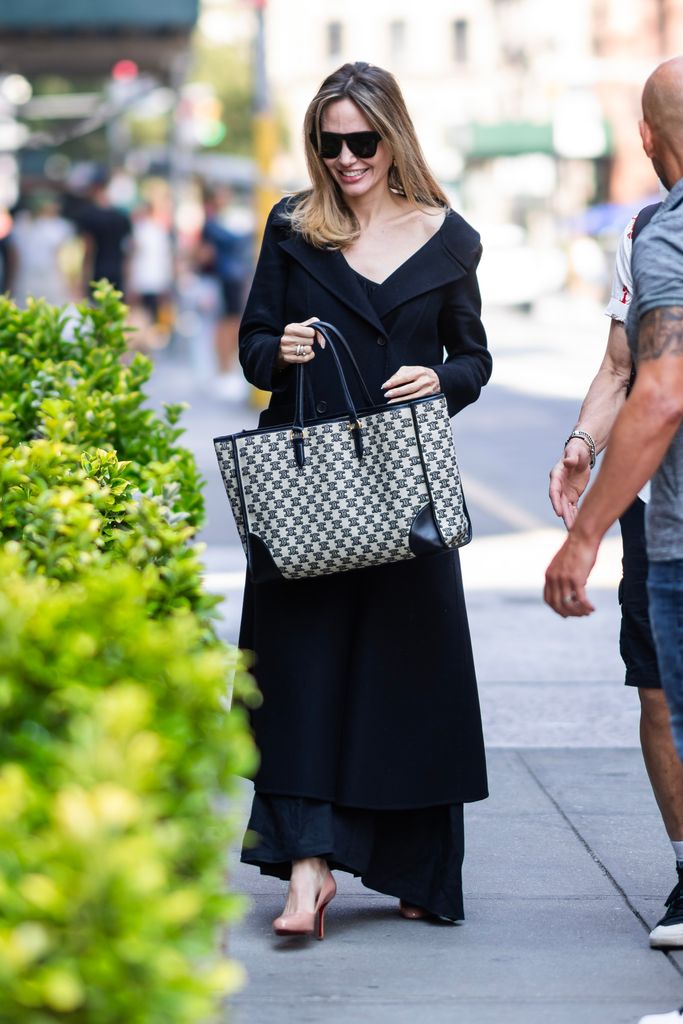 Angelina on street in a black slip dress