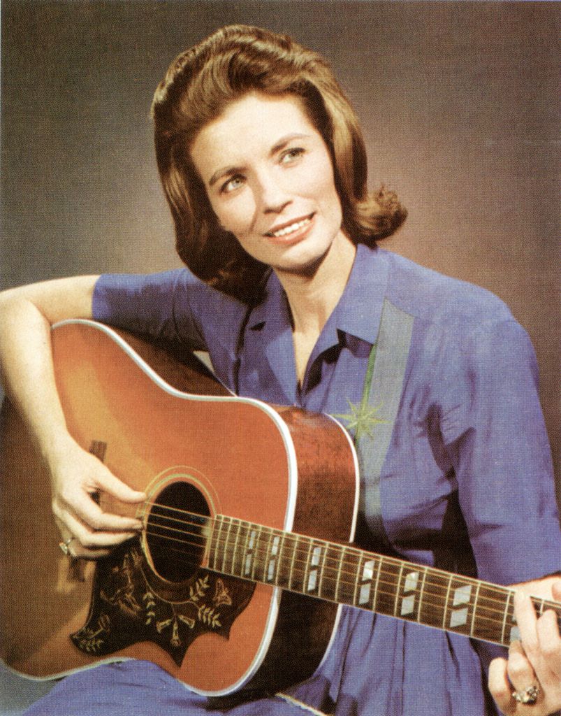 Photo of American singer and actress June Carter (1929-2003) posed playing an acoustic guitar circa 1965.