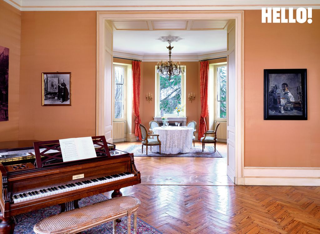 Un salon à parois orange avec un piano dans le coin gauche à Château Toulouse-Lautrec