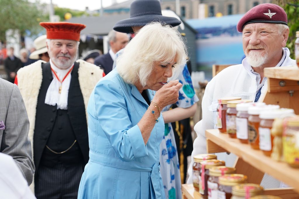 Queen Camilla tasting local honey during a visit to Jersey