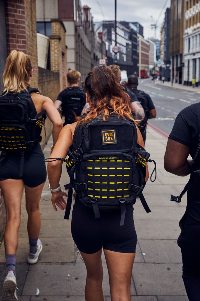 Group of people running wearing gymbox backpacks 