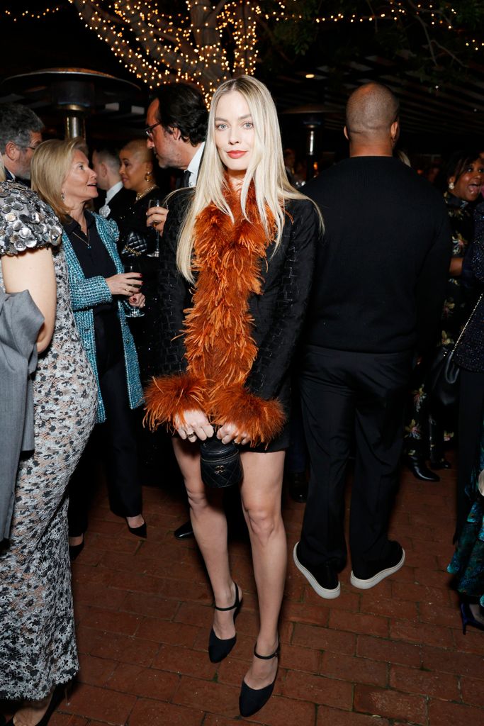 Margot Robbie rocks wild feathered mini dress and poker straight hair