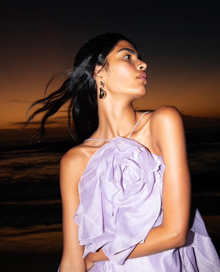 women in lilac aje dress by the beach 