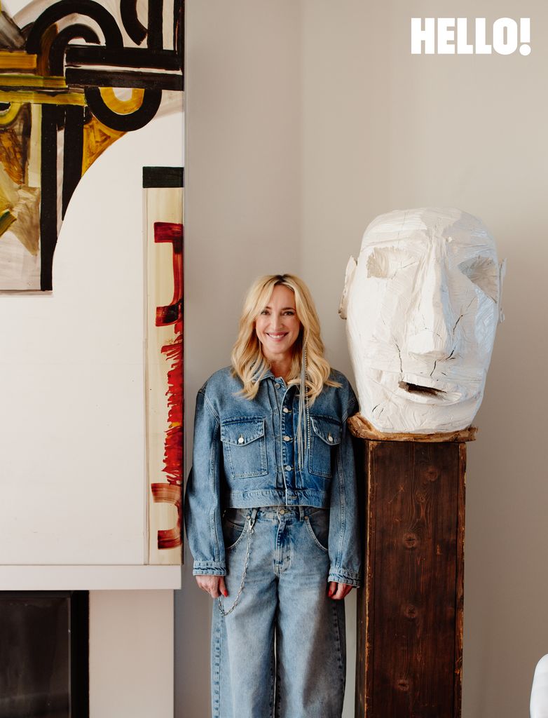 Inge poses in double denimn alongside the large wooden head in the three-storey apartment in Antwerp’s Graanmarkt Square