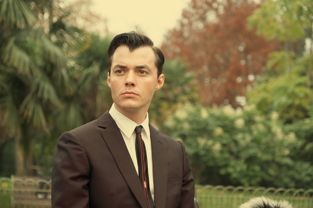 Man in suit in front of trees