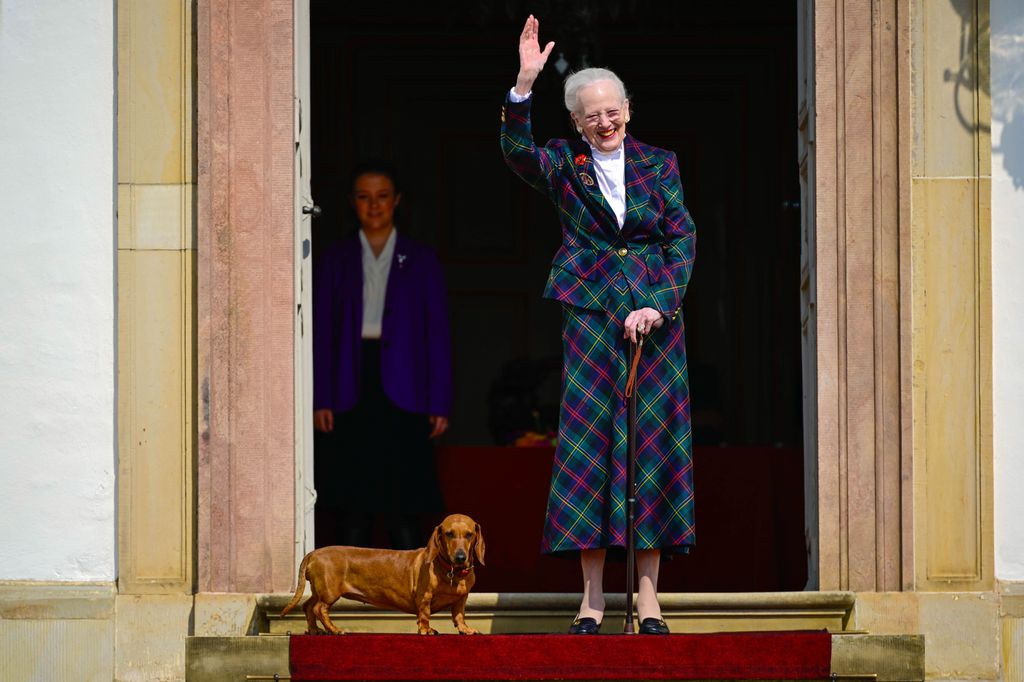 Queen Margrethe waves from Fredensborg Palace with dog
