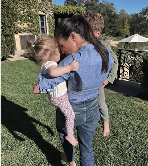 Meghan Markle holding her children Archie and Lilibet in garden of Montecito home