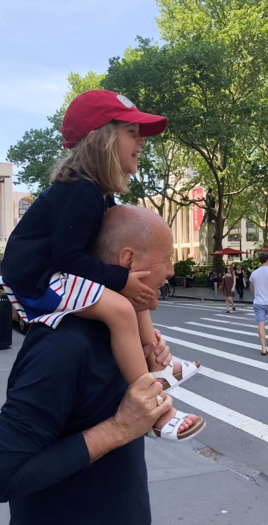 Still from a throwback video shared by Bruce Willis' wife Emma Heming in which he is walking around New York City with his daughter Evelyn sitting on his shoulders