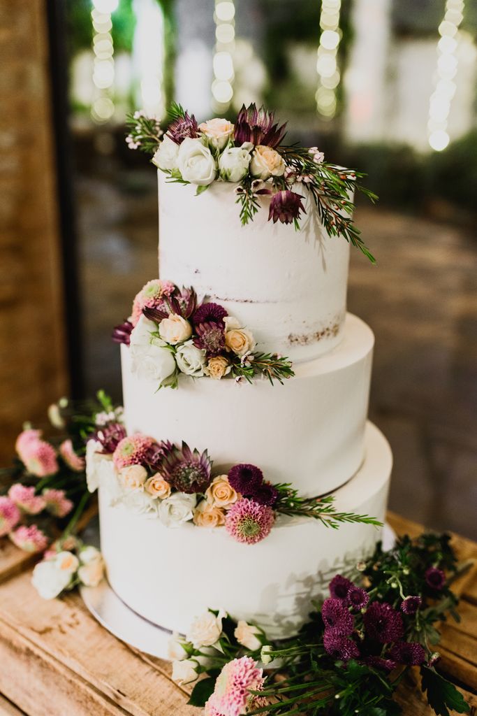 Three-tier wedding cake with red and pink flowers