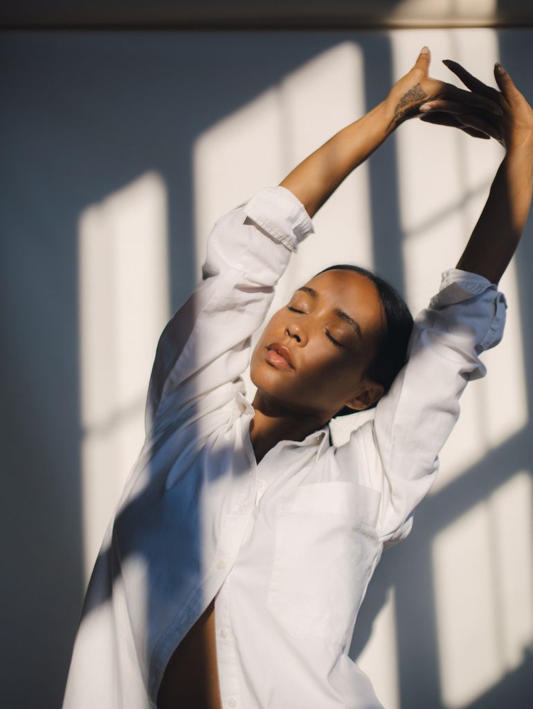 woman stretching in a white shirt 