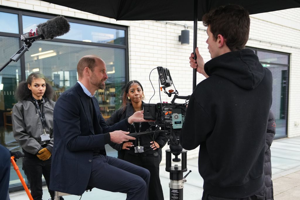 Prince William sat on a dоlly with three students stаnding around him