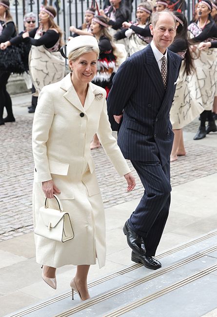 sophie wessex in white suit alongside prince edward climbing up steps of westminster abbey