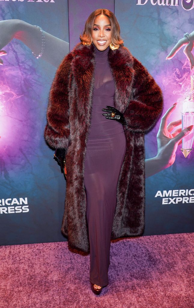 Kelly Rowland poses in purple dress and fur coat