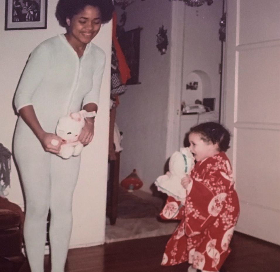 A baby Meghan Markle and Doria Ragland playing with toy cats