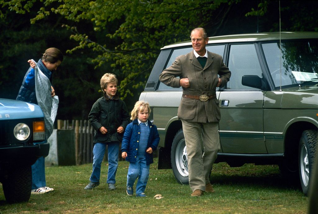 Princess Anne and Prince Philip walking with a young Peter Phillips and Zara Tindall