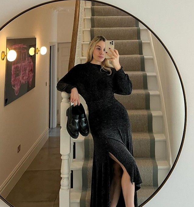Holly Ramsay modelling a gorgeous black dress with thigh split as she takes a mirror selfie 