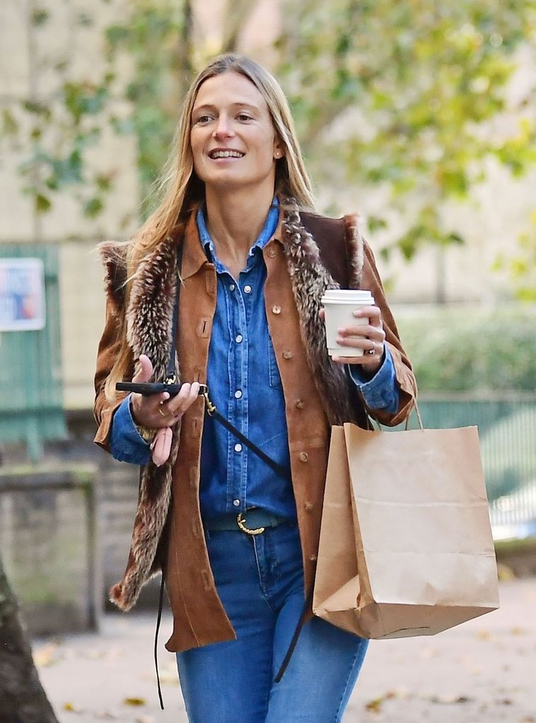 Alizee Thevenet wears double denim outfit and holds a coffee