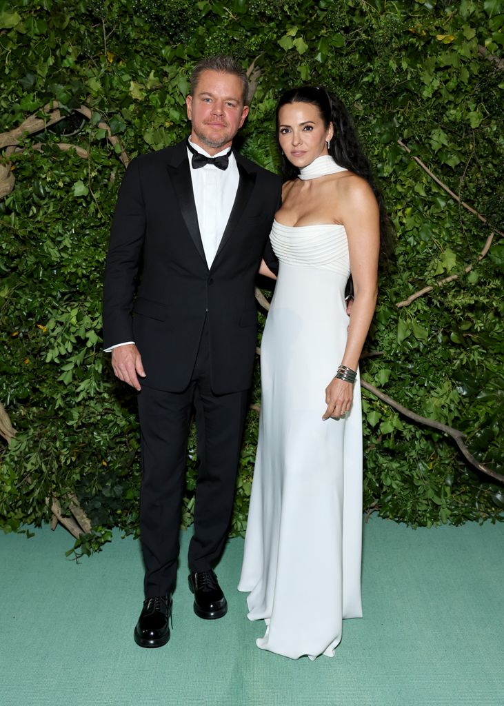 Matt Damon in a suit and his wife in a white dress