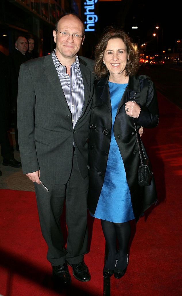 man and woman smiling on red carpet