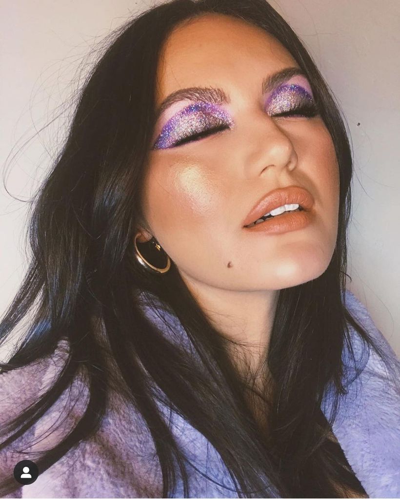 Woman with disco sparkle purple eye makeup 