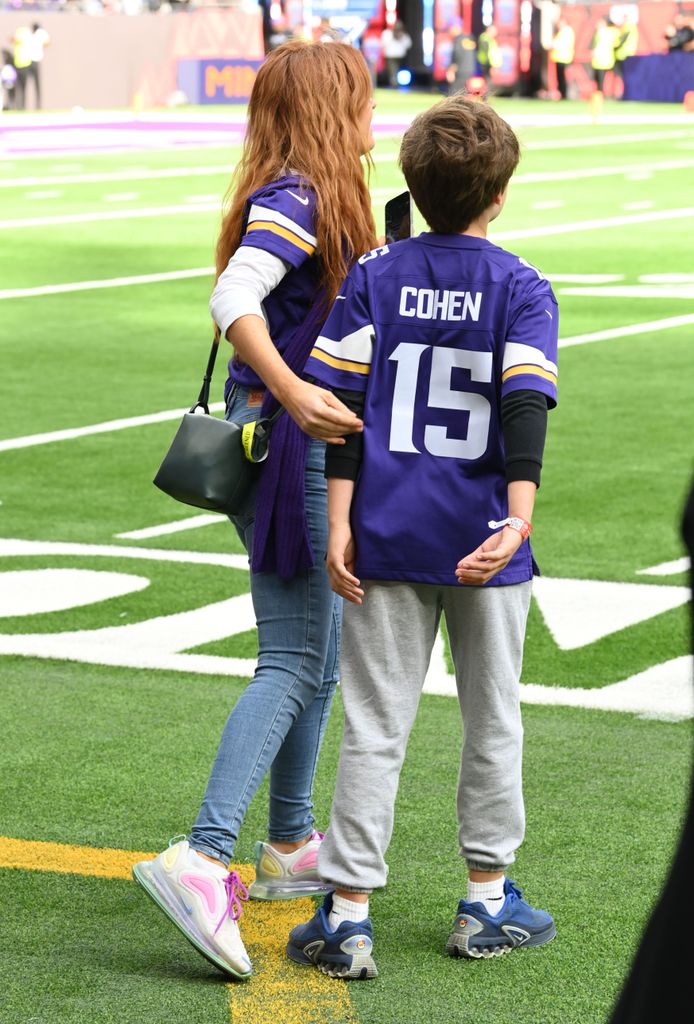 Isla and her son on the football field and his shirt says Cohen on the back