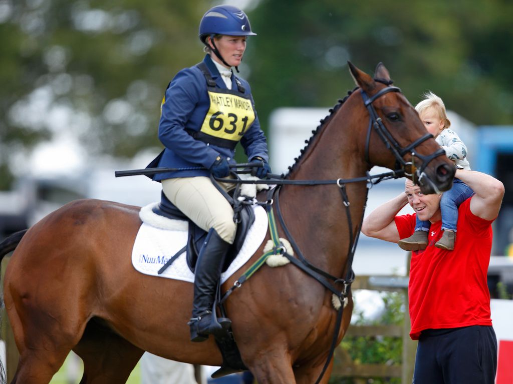 Zara Tindall riding a horse while Mike Tindall watches on