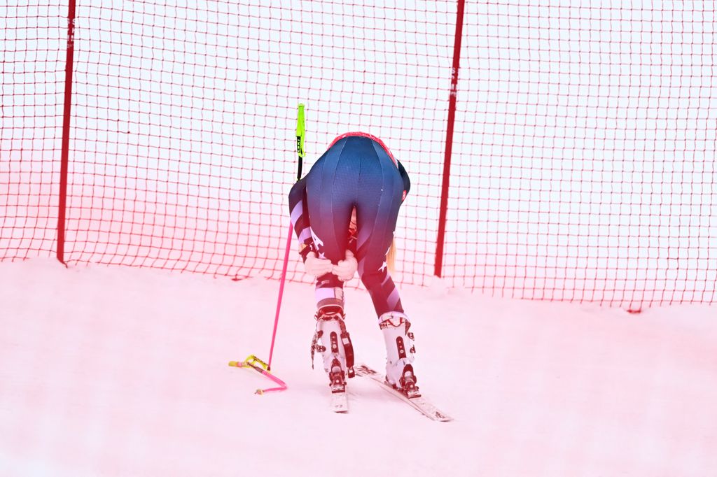 Lindsey Vonn holds the back of her knee after crashing in the women's downhill race part of the FIS Alpine Ski World Cup 2025-2026, in Crans Montana, Switzerland, on January 30, 2026