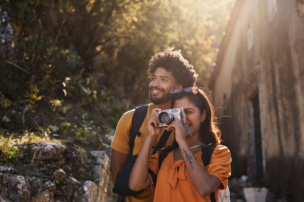 Woman photographing through camera by boyfriend