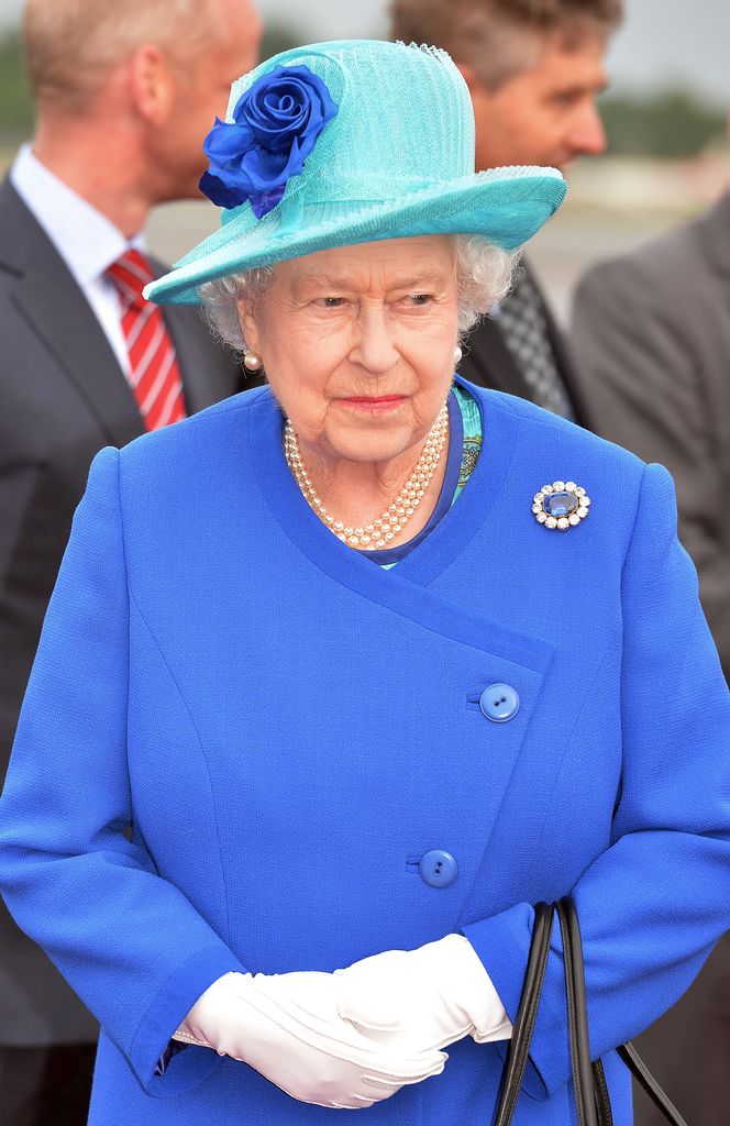 Rainha Elizabeth em roupa azul e luvas brancas