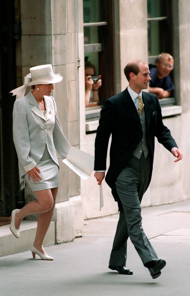 Sophie Rhys-Jones in skirt suit and top hat walking behind edward