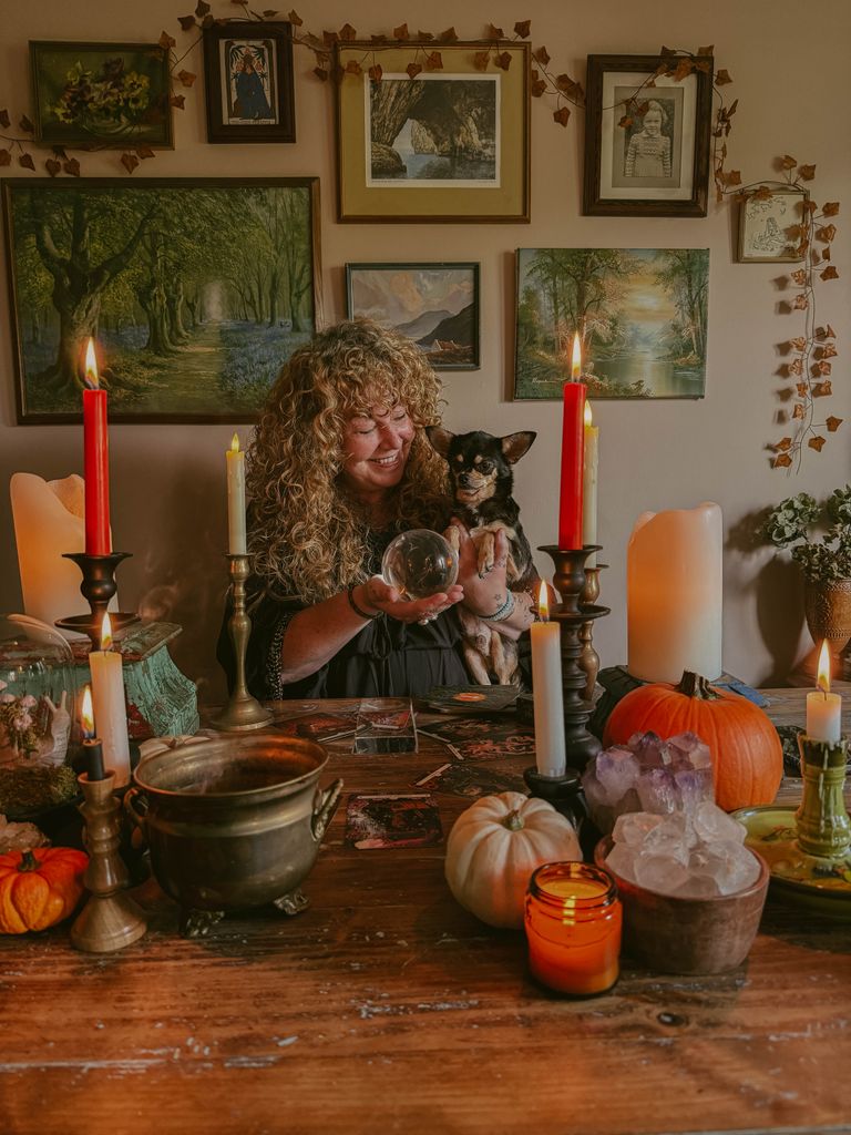 Emma and her chihuahua Walter pose behind a table laden with pumpkins and candles