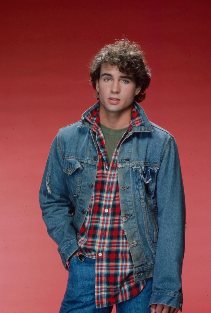 Jason in 1985 with curly hair and denim outfit