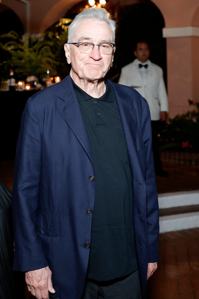 Robert de Niro dans une chemise noire et un blazer bleu marine