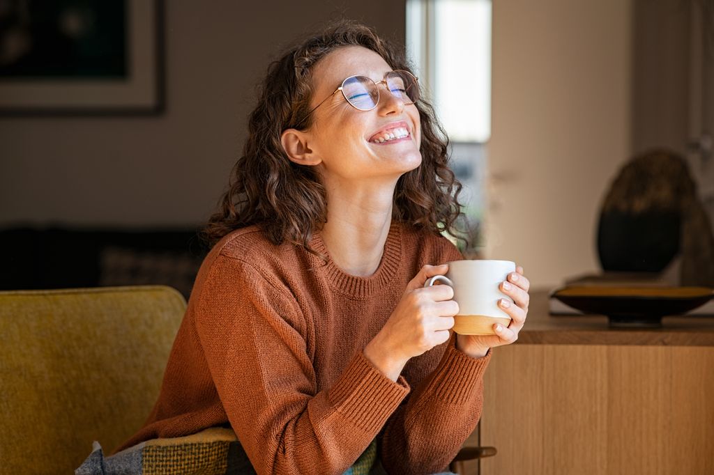 Young woman smiling with a coffee